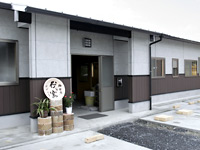 白い外壁の建物の入り口写真